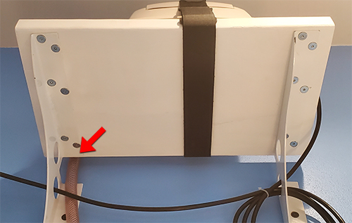 Gap highlighted between the wall and the shelf. This shelf does not rest up against the wall. Rather a small gap runs parallel with the wall to allow for tube management.